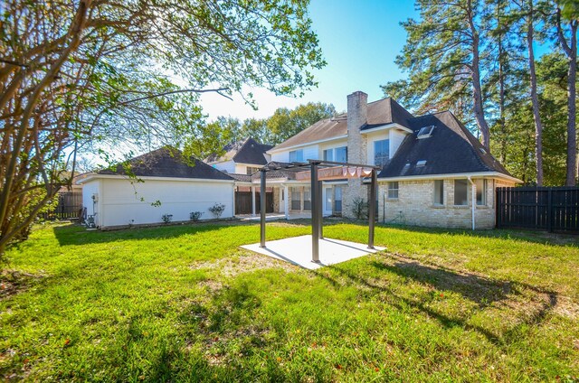 rear view of property featuring a patio area, a pergola, and a yard