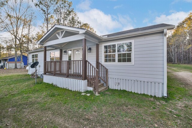 view of front facade featuring covered porch and a front yard