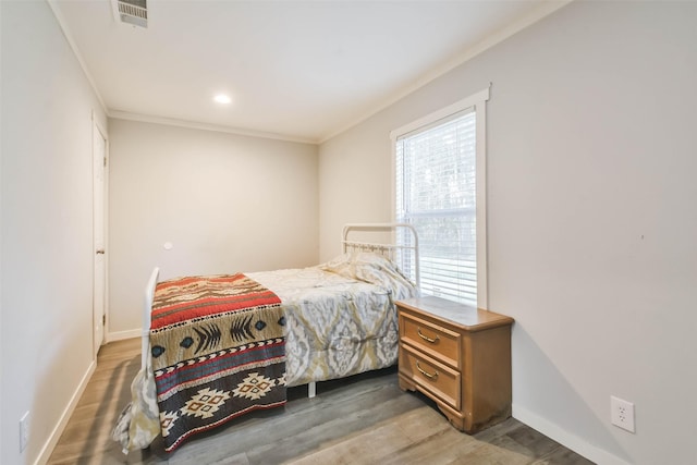 bedroom with dark hardwood / wood-style flooring and crown molding