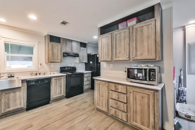 kitchen with black appliances, light wood-type flooring, sink, and ornamental molding