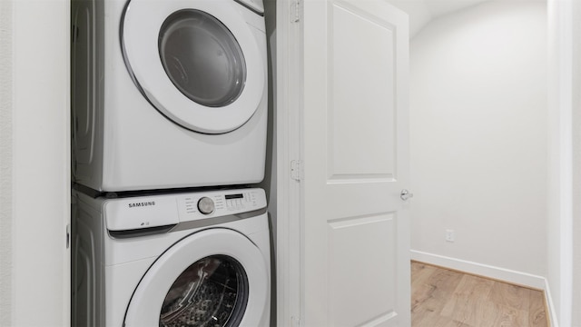 washroom featuring light hardwood / wood-style floors and stacked washer and clothes dryer