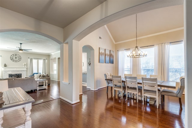 dining area featuring a wealth of natural light, dark hardwood / wood-style floors, and ceiling fan with notable chandelier