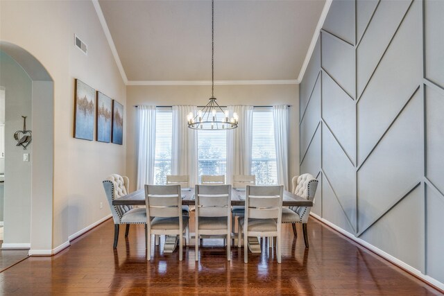 dining room with wood-type flooring, lofted ceiling, an inviting chandelier, and ornamental molding