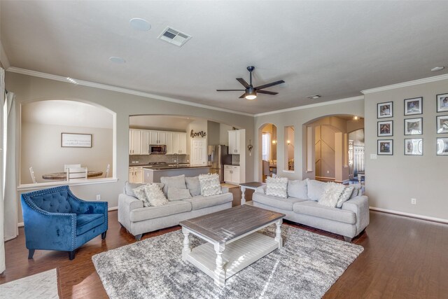 living room featuring dark hardwood / wood-style flooring, ceiling fan, and ornamental molding