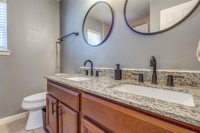 bathroom featuring toilet, vanity, tile patterned floors, and plenty of natural light