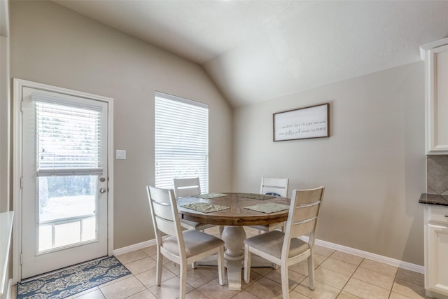 tiled dining area with lofted ceiling