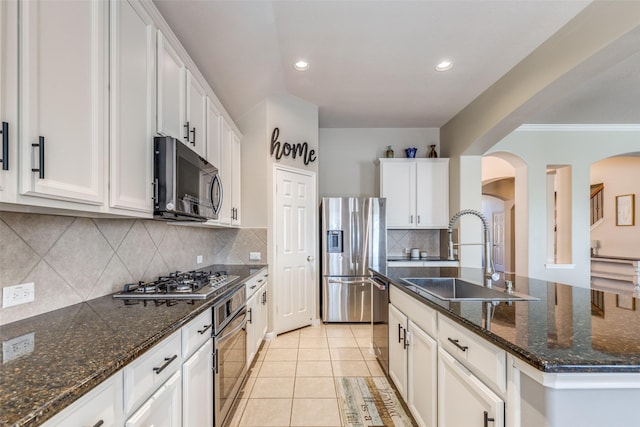 kitchen with sink, light tile patterned floors, tasteful backsplash, white cabinetry, and stainless steel appliances