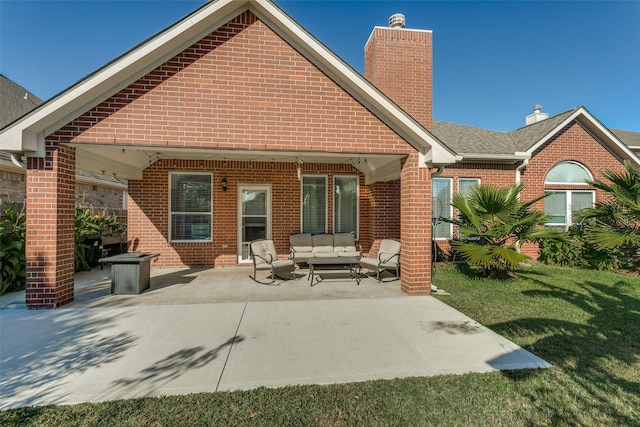 rear view of house with a lawn, an outdoor living space, and a patio area