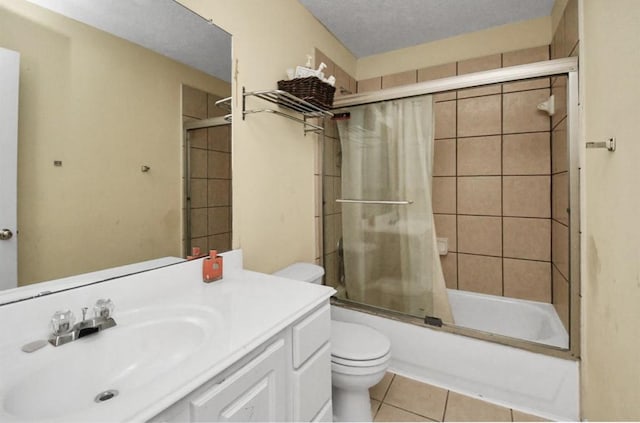 full bathroom featuring vanity, combined bath / shower with glass door, tile patterned flooring, toilet, and a textured ceiling