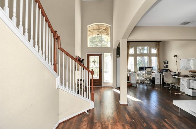 entryway with a towering ceiling and dark hardwood / wood-style floors