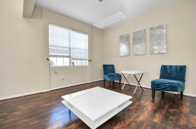 living area with a notable chandelier and dark wood-type flooring