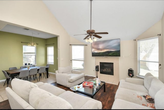 living room with a tile fireplace, ceiling fan, tile patterned flooring, and a wealth of natural light