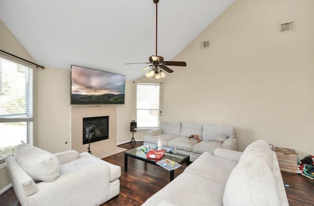 living room featuring a fireplace, vaulted ceiling, ceiling fan, and dark wood-type flooring