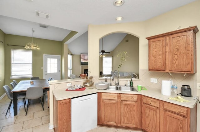 kitchen with a wealth of natural light, dishwasher, sink, light tile patterned floors, and ceiling fan with notable chandelier