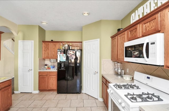 kitchen featuring light tile patterned flooring, white appliances, and tasteful backsplash