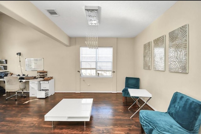 living area with dark wood-type flooring and a notable chandelier