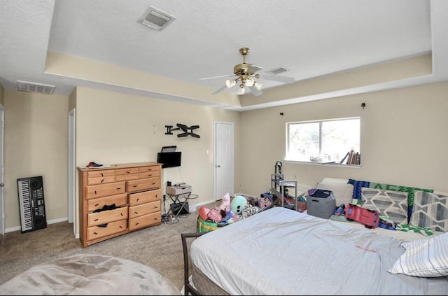 bedroom with light carpet, a raised ceiling, and ceiling fan