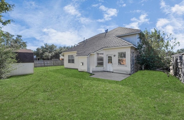 rear view of house with a shed, a yard, and a patio