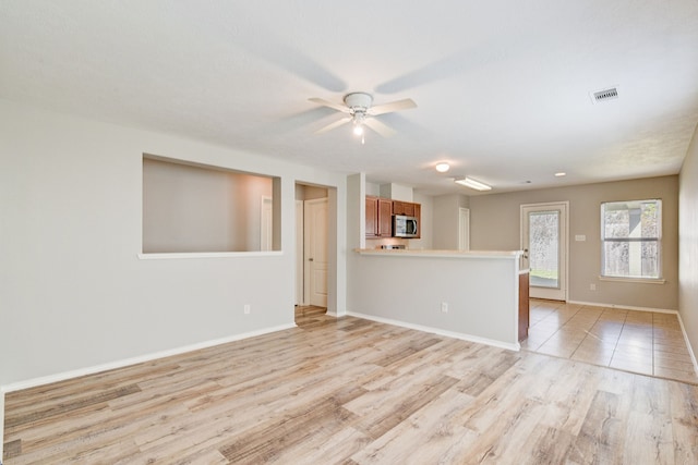 unfurnished living room with ceiling fan and light hardwood / wood-style floors