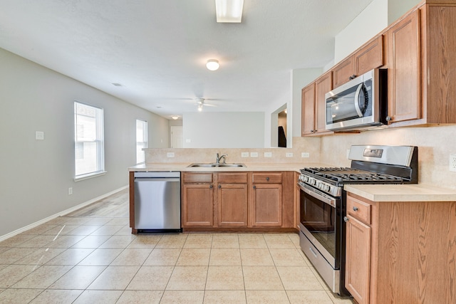 kitchen with kitchen peninsula, appliances with stainless steel finishes, backsplash, and ceiling fan