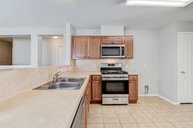 kitchen featuring backsplash, light tile patterned flooring, sink, and stainless steel appliances