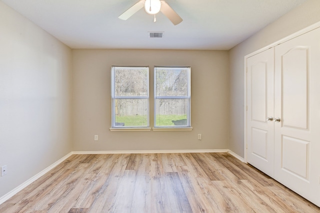 unfurnished bedroom featuring ceiling fan, light hardwood / wood-style floors, and a closet