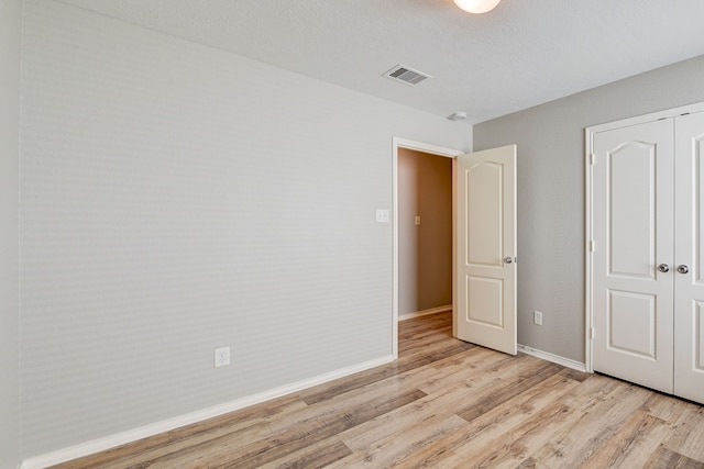 unfurnished bedroom featuring light hardwood / wood-style floors and a closet