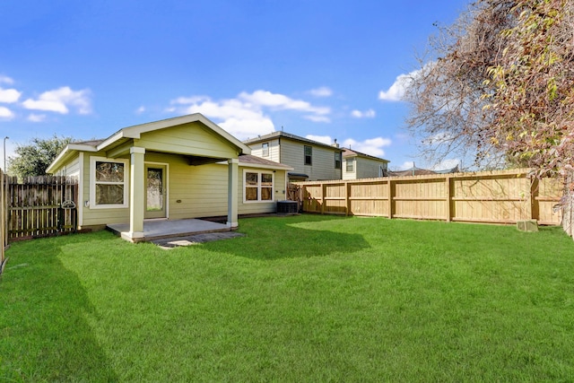 back of house with central AC, a patio area, and a lawn