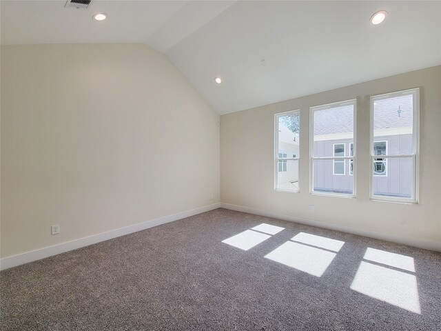 unfurnished room featuring lofted ceiling and carpet floors