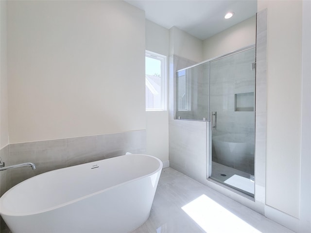 bathroom featuring tile walls and plus walk in shower