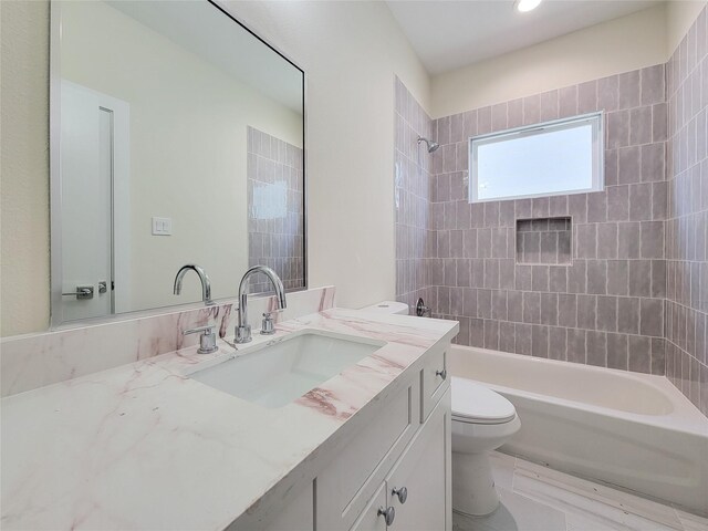 full bathroom featuring tiled shower / bath combo, toilet, and vanity