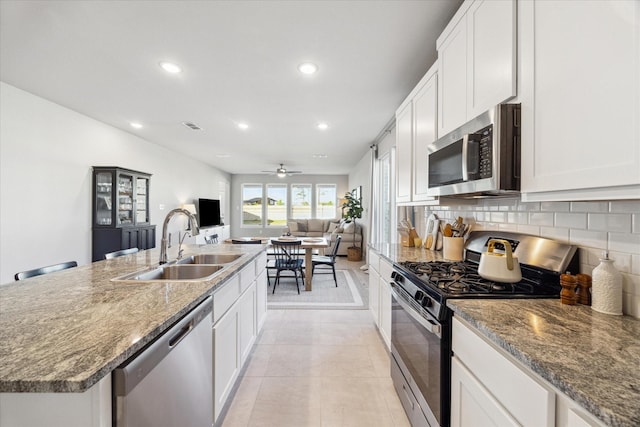 kitchen with white cabinets, appliances with stainless steel finishes, ceiling fan, and sink