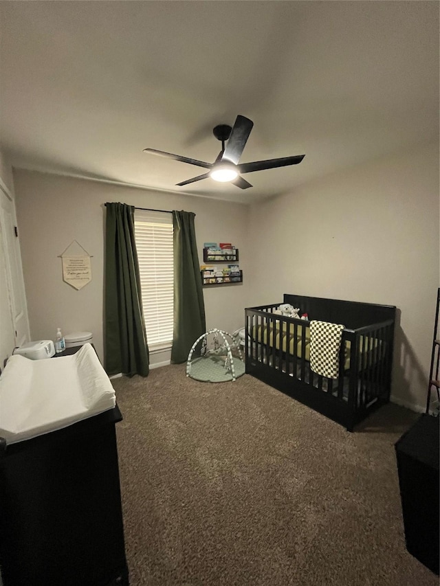 carpeted bedroom with a nursery area and ceiling fan