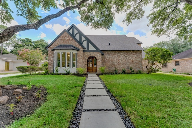 tudor house with a front yard and french doors