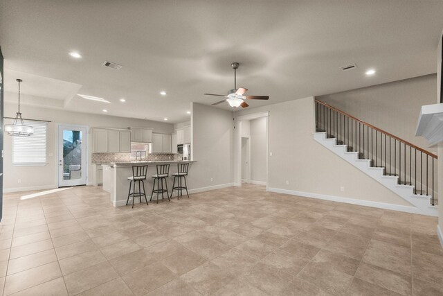 unfurnished living room featuring ceiling fan