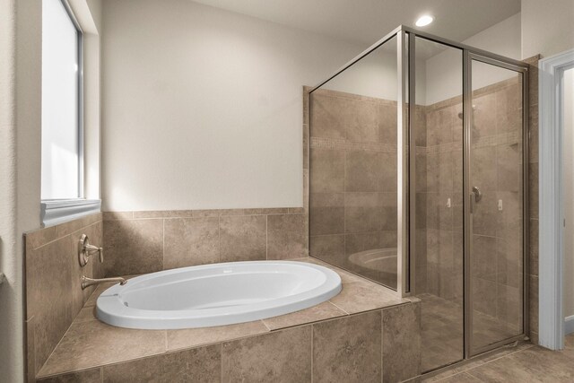 bathroom featuring tile patterned floors, plenty of natural light, and independent shower and bath