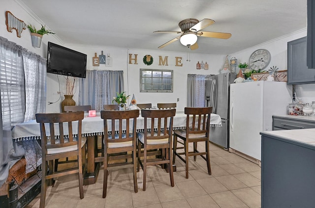 dining area featuring crown molding, ceiling fan, and light tile patterned flooring