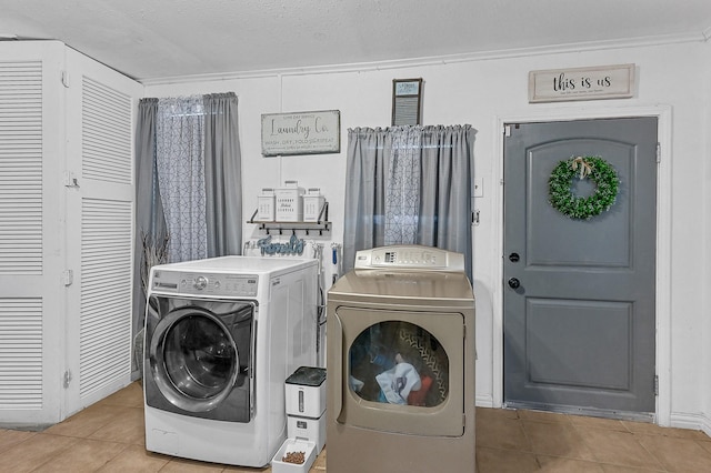 laundry area with crown molding, light tile patterned floors, a textured ceiling, and independent washer and dryer