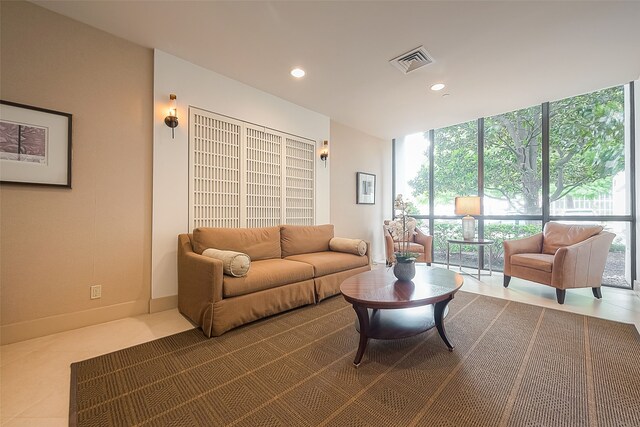 tiled living room featuring floor to ceiling windows