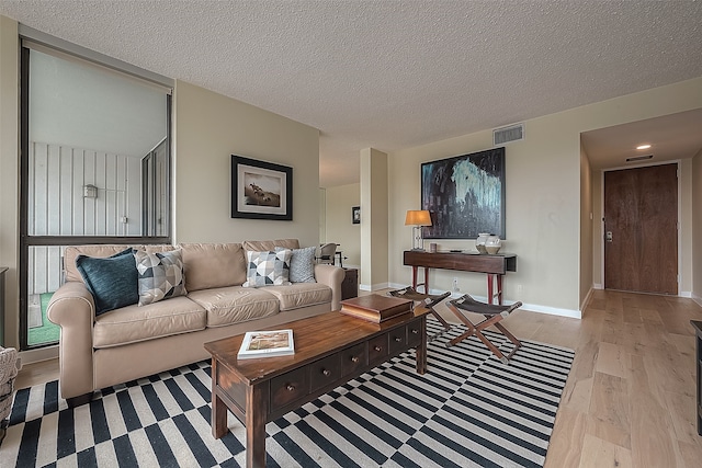 living room featuring a textured ceiling and light hardwood / wood-style floors