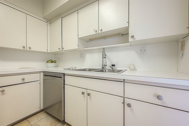 kitchen with white cabinets, dishwasher, light tile patterned floors, and sink