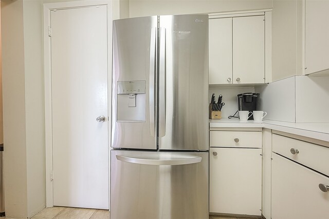 kitchen with white cabinetry and stainless steel refrigerator with ice dispenser