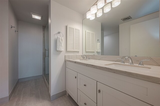 bathroom with a shower with door and vanity