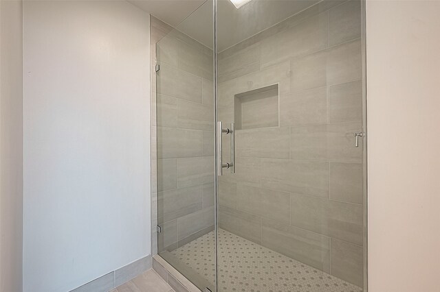 bathroom featuring tile patterned flooring and an enclosed shower