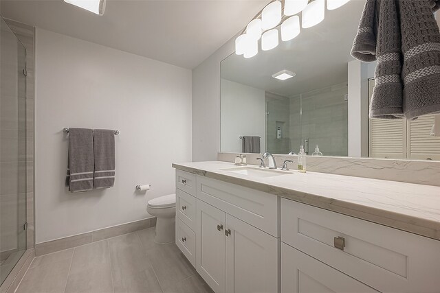 bathroom with tile patterned floors, vanity, toilet, and walk in shower