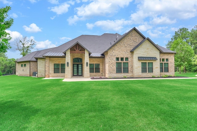 rear view of house featuring a lawn, french doors, and central AC