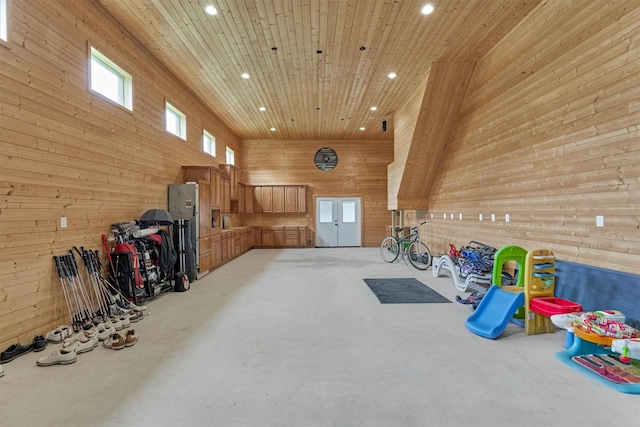 rec room featuring wooden ceiling, wooden walls, and a towering ceiling