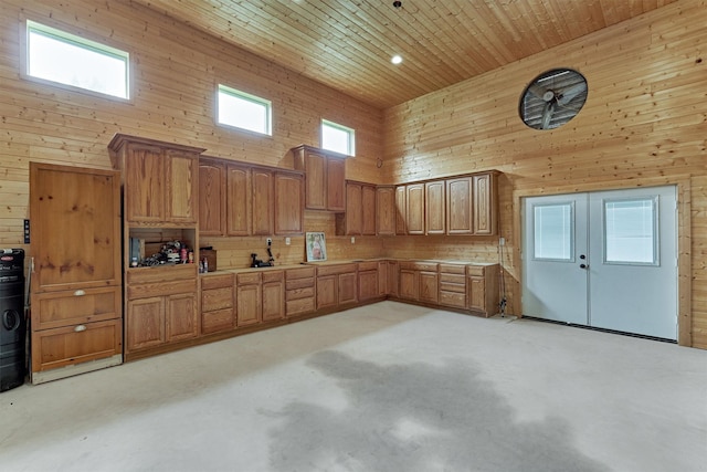 kitchen featuring a towering ceiling, wooden ceiling, and wooden walls