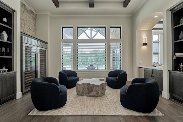 living area featuring wine cooler, built in features, and ornamental molding