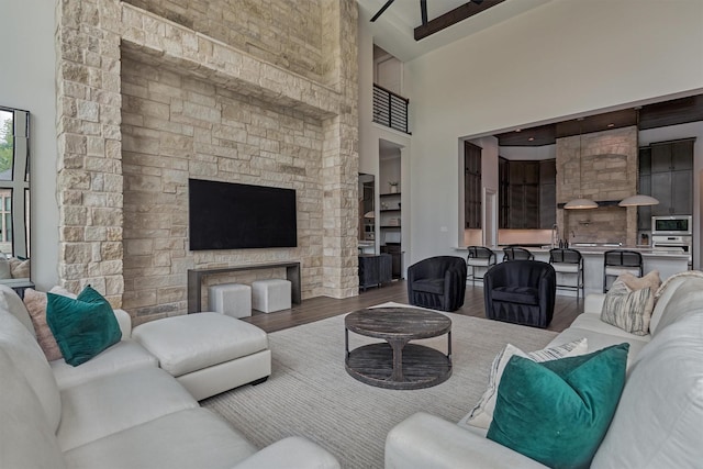 living room featuring beamed ceiling, wood-type flooring, and high vaulted ceiling